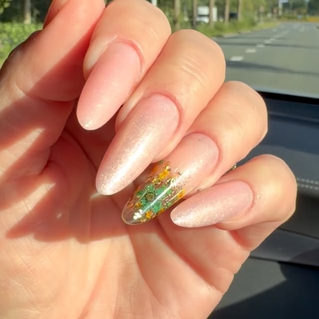 Nude shimmer amandelnagels met een droogbloem accent